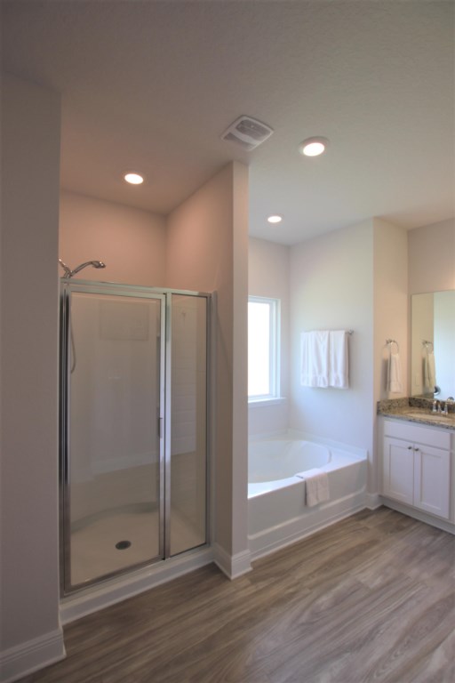 Attached primary bath with large soaking tub, walk-in shower, and private water closet