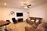 The second living room offers comfortable seating with flat screen television and additional private entrance 