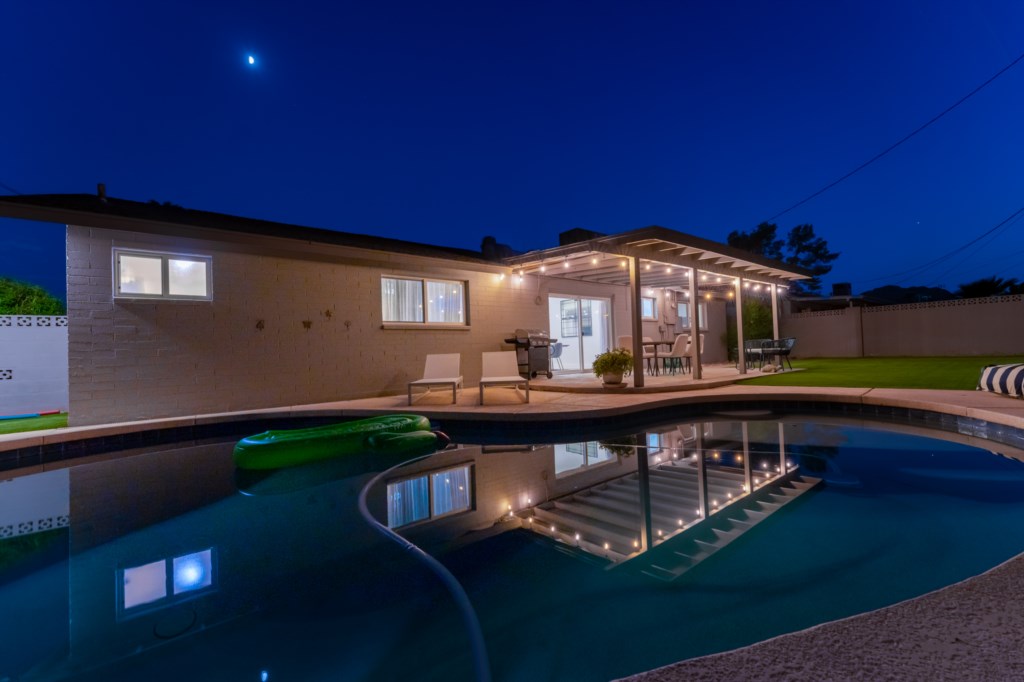 Night view of the pool/backyard area with Papago Park mountains in the background. 