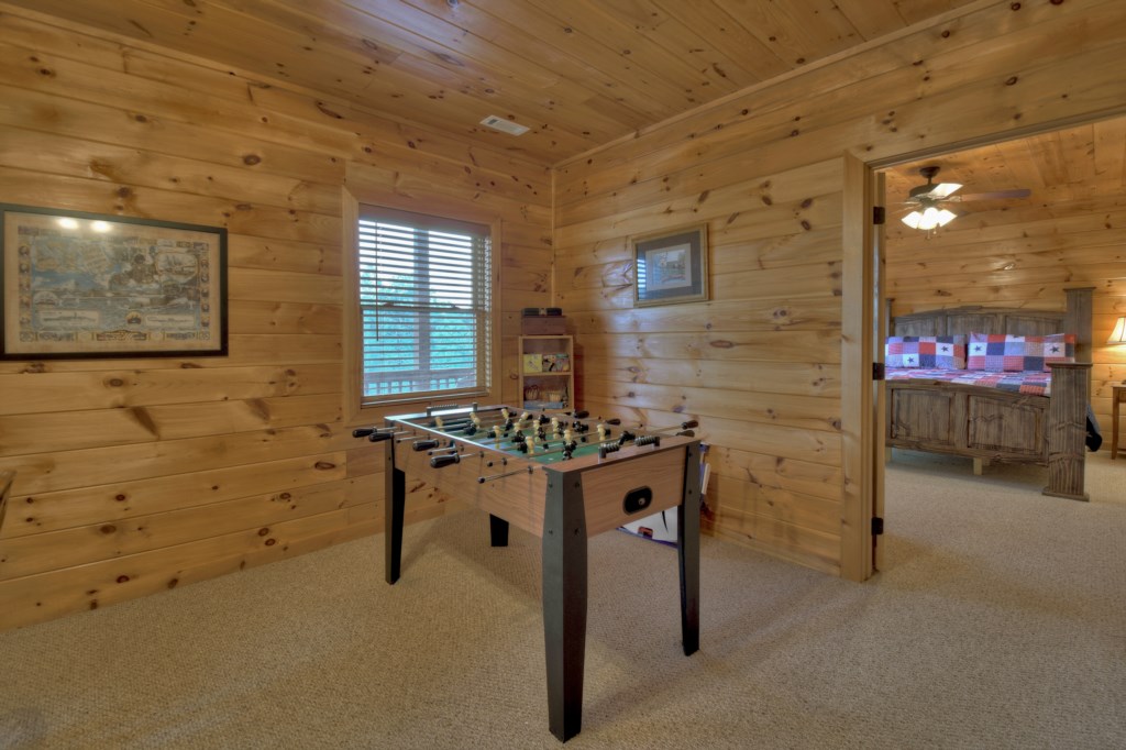 Terrace level game room with corn hole, foosball table, board games and a tv
