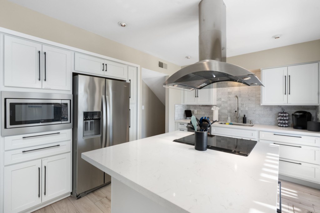 Modern kitchen with stainless steel appliances and spacious island for meal prep.