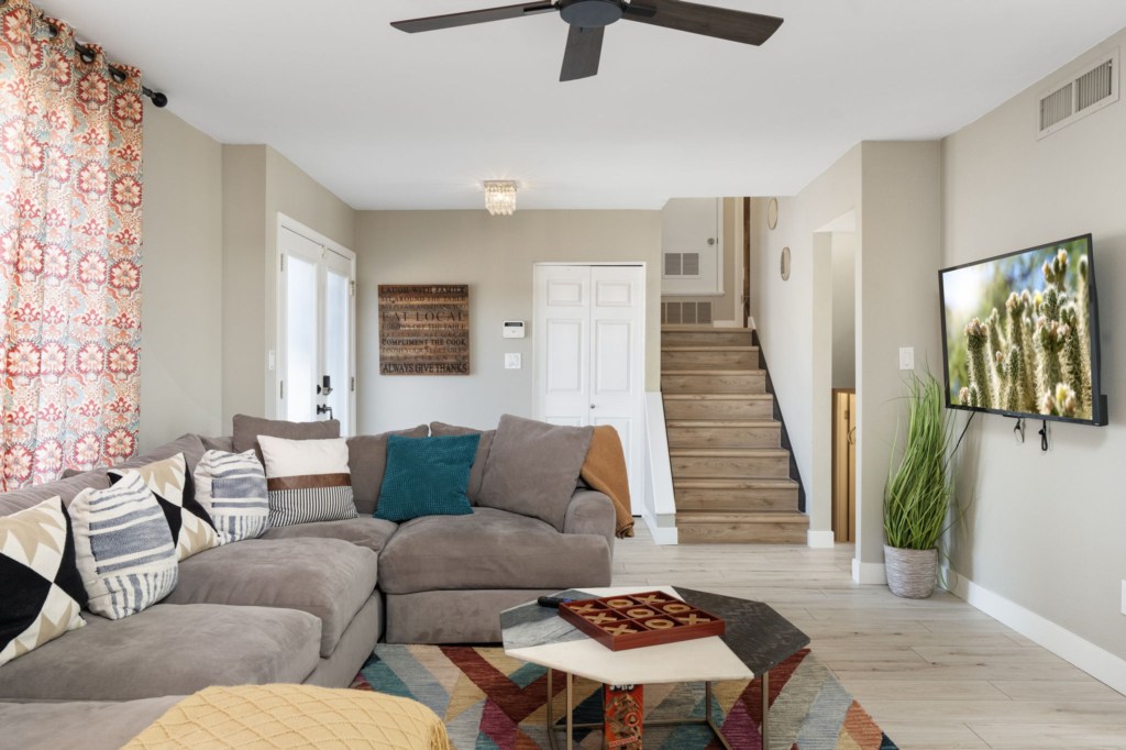 Bright living room with cozy sectional sofa and wall-mounted TV, perfect for relaxing evenings.