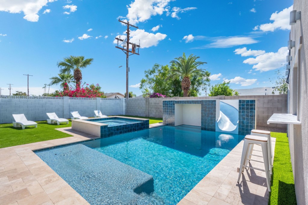 Private pool with water slide and sun loungers, perfect for fun-filled days in the sun.