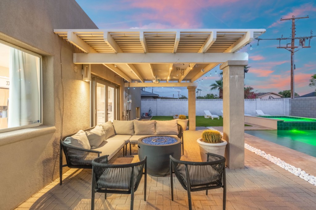 Relax in the outdoor patio with cozy seating and a fire pit, perfect for evening gatherings.
