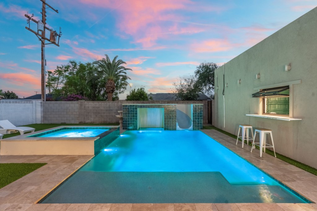 Relax by the private pool with a waterfall feature and outdoor bar seating.