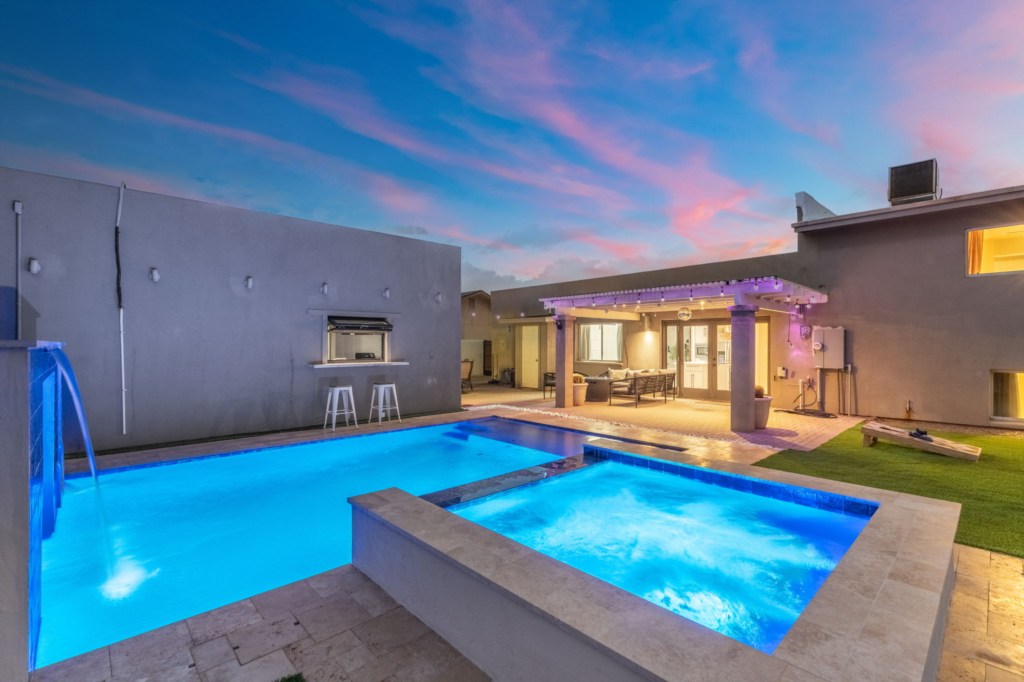 Relax by the illuminated private pool with waterfall feature and spacious patio seating.