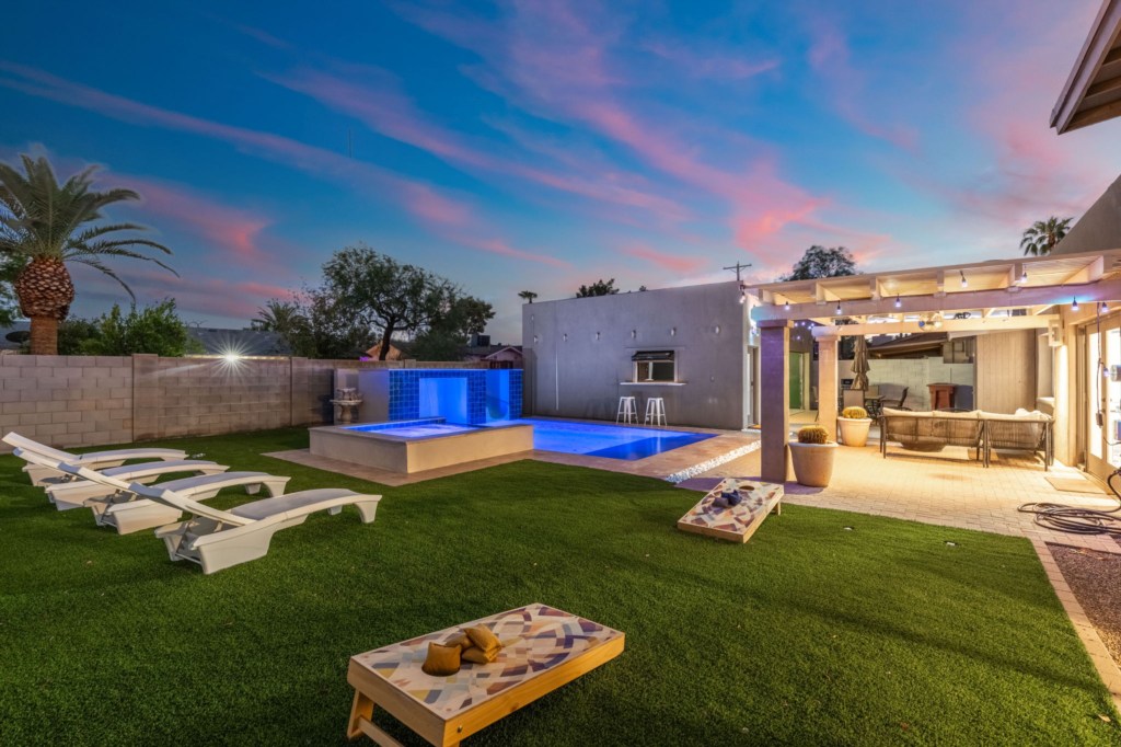 Chic backyard with pool, lounge chairs, and covered patio for relaxing evenings.