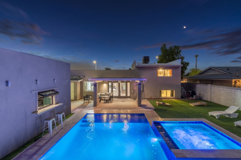 Stunning nighttime view of the pool and hot tub, perfect for evening relaxation and entertainment.
