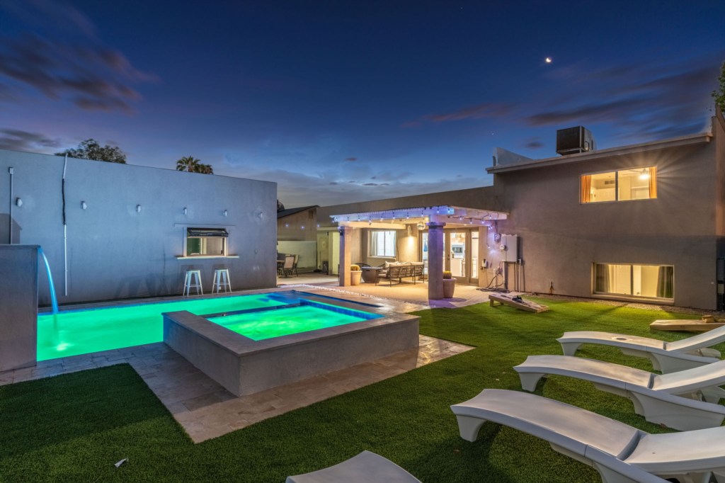 Luxurious outdoor pool and spa area with cozy seating for evening relaxation.