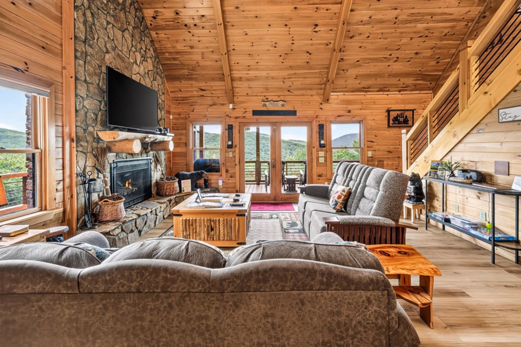 Cozy living room with a stone fireplace and mountain views, perfect for relaxing evenings.