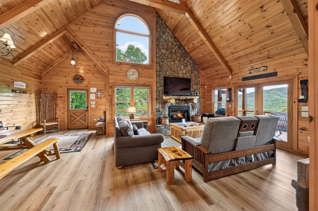 Rustic living room with vaulted ceilings and a cozy fireplace, offering stunning mountain views.