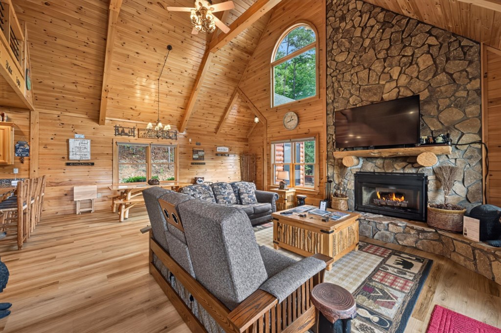 Rustic living room with vaulted ceilings, stone fireplace, and cozy seating for relaxation.