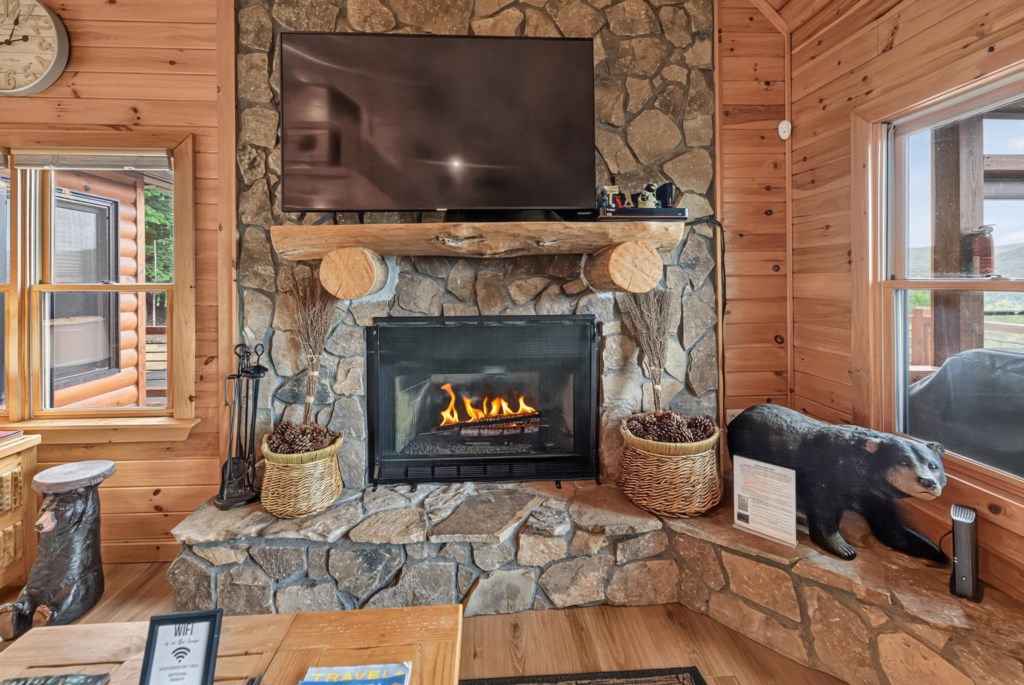Rustic living room with stone fireplace and cozy cabin decor.