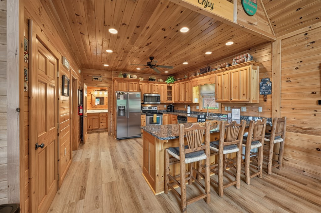 Rustic kitchen with granite countertops and breakfast bar seating for five.