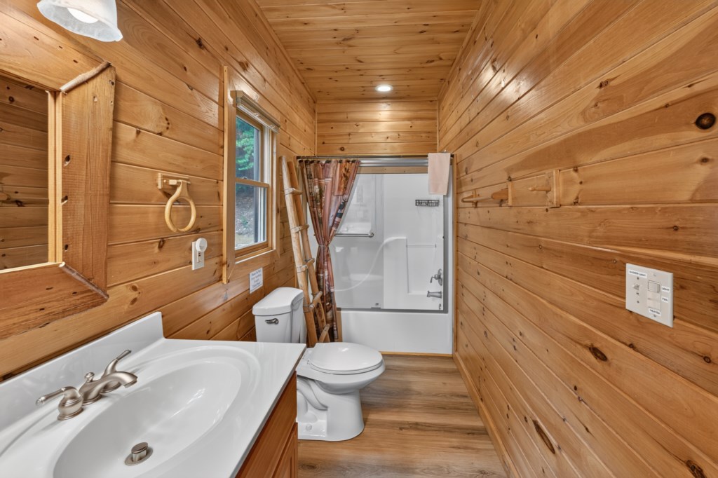 Rustic bathroom with wood paneling and a walk-in shower.