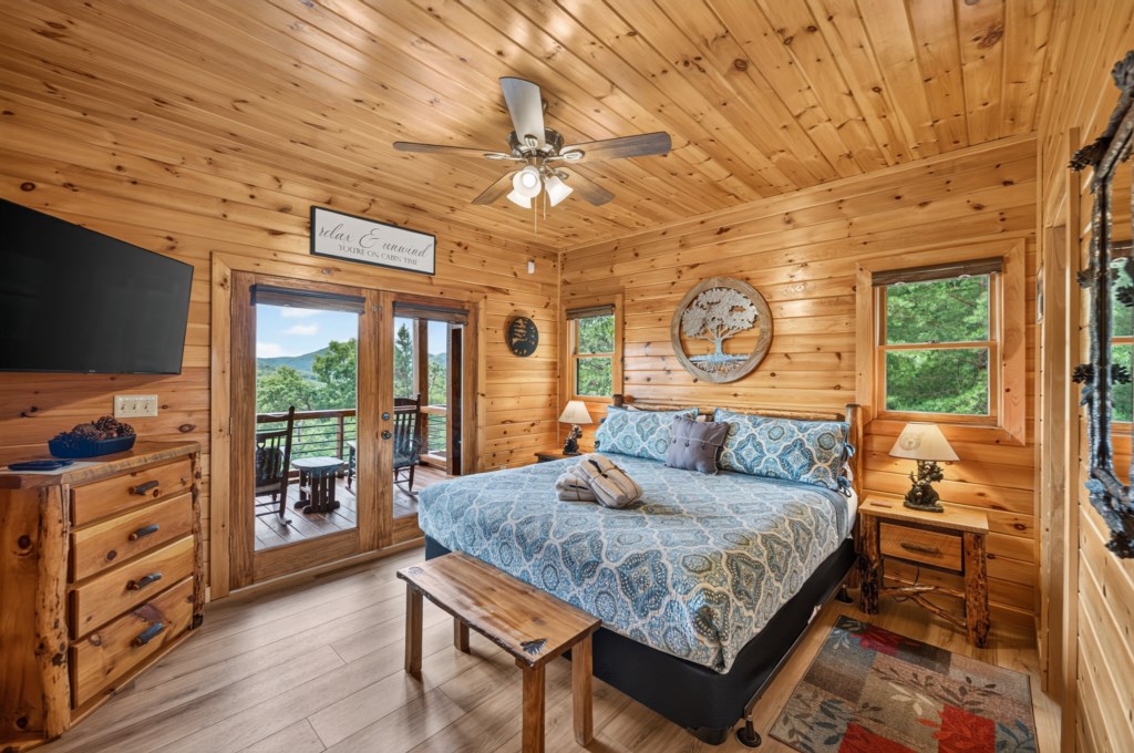 Cozy cabin bedroom with mountain views and private balcony access.