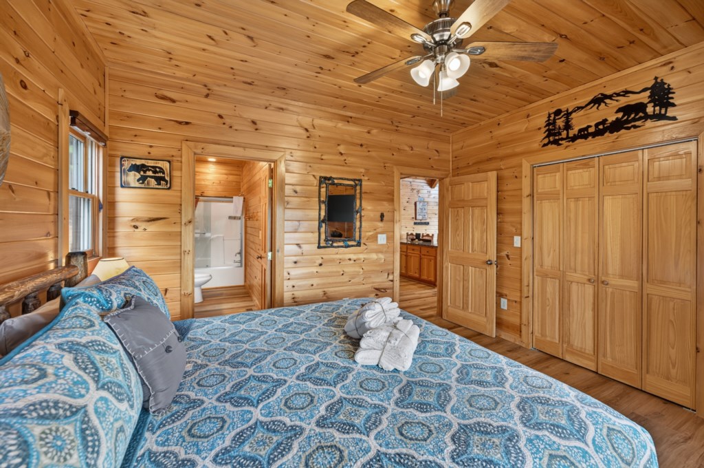 Rustic bedroom with en-suite bathroom and cozy log cabin decor.