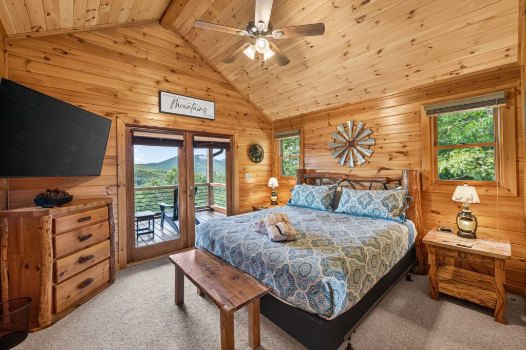 Cozy cabin bedroom with mountain views and private balcony access.