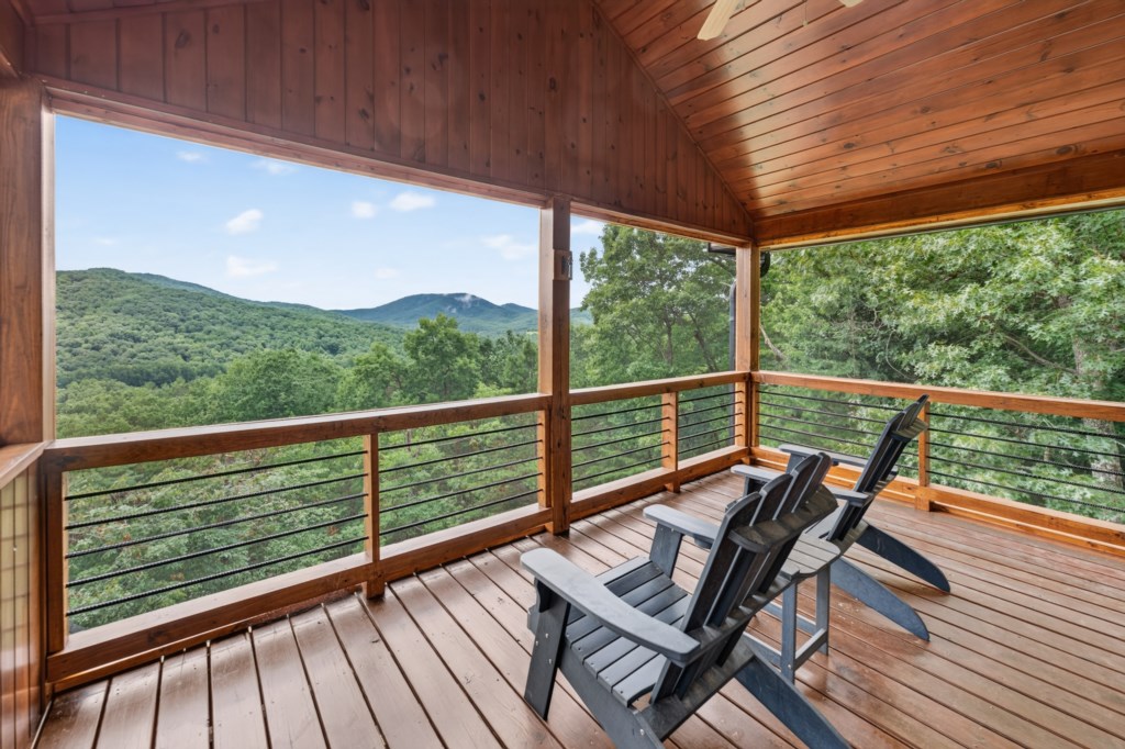 Relax on the spacious deck with stunning views of the lush mountain landscape.