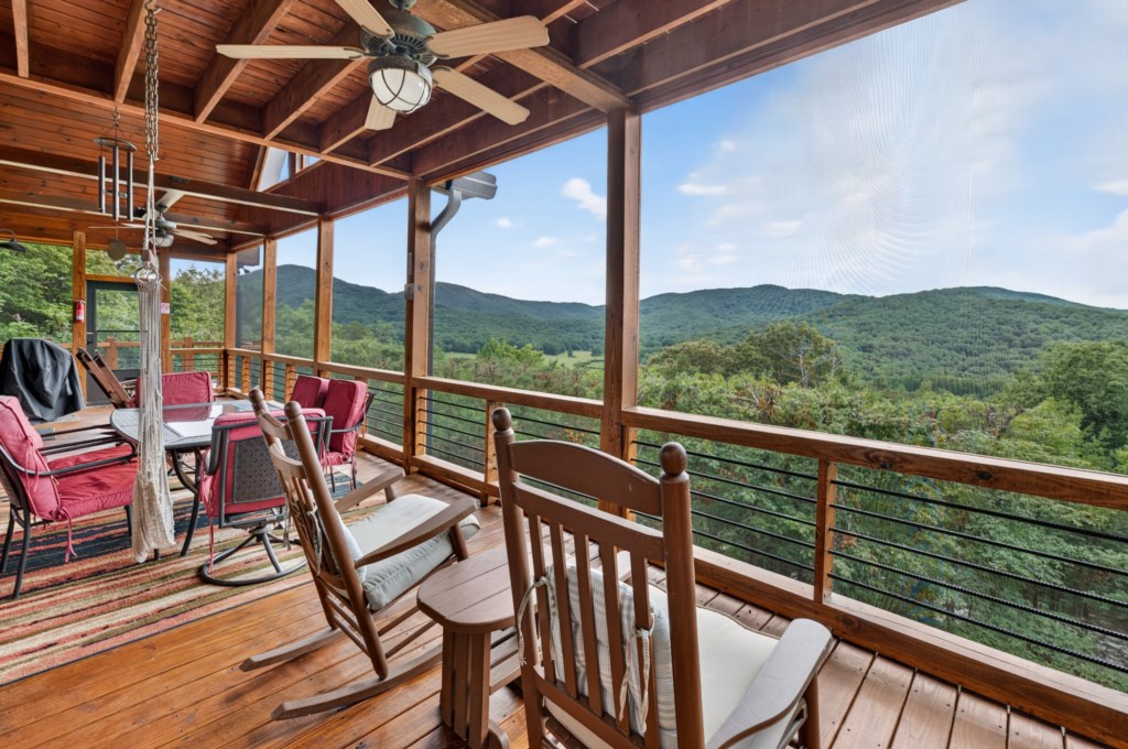 Spacious deck with rocking chairs and mountain views, perfect for relaxing afternoons.