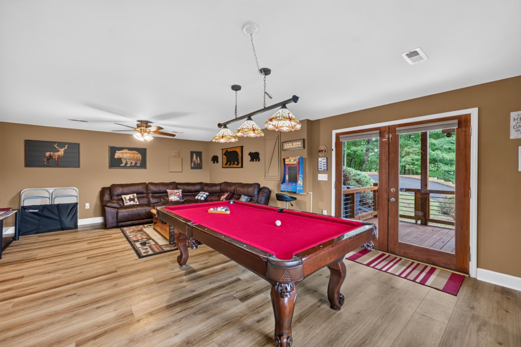 Cozy game room with pool table and arcade, perfect for family fun.