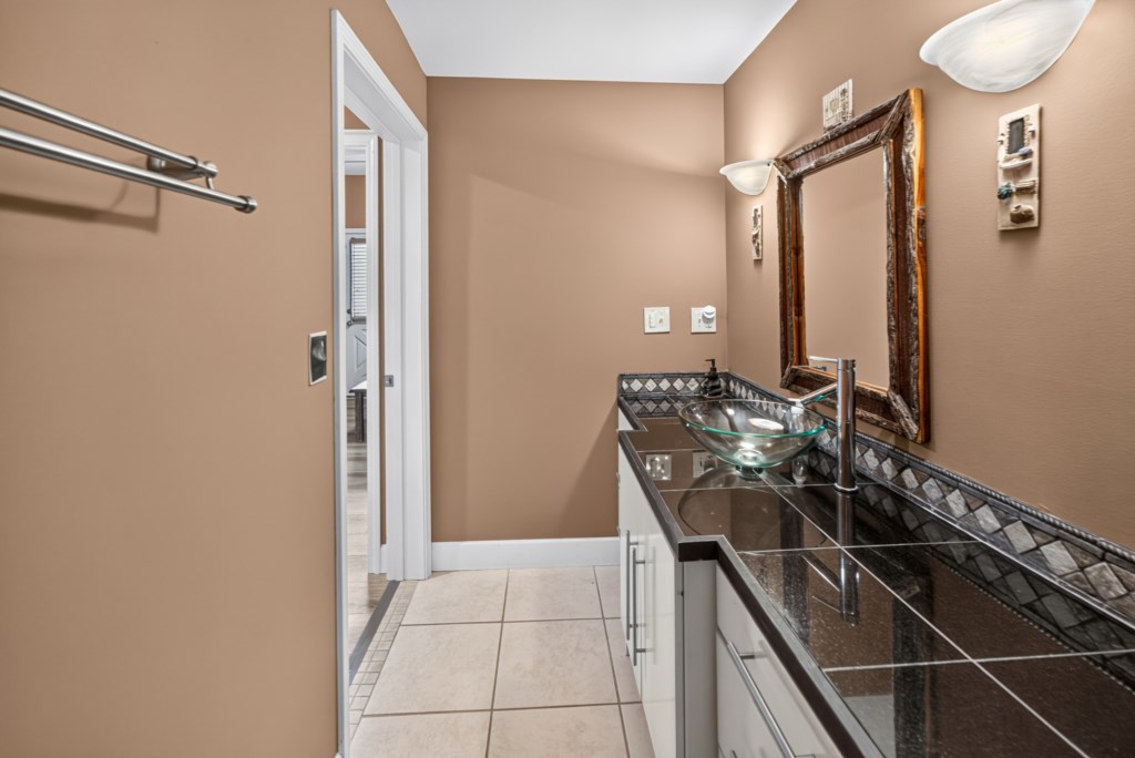 Elegant bathroom with a modern glass sink and stylish tile accents.