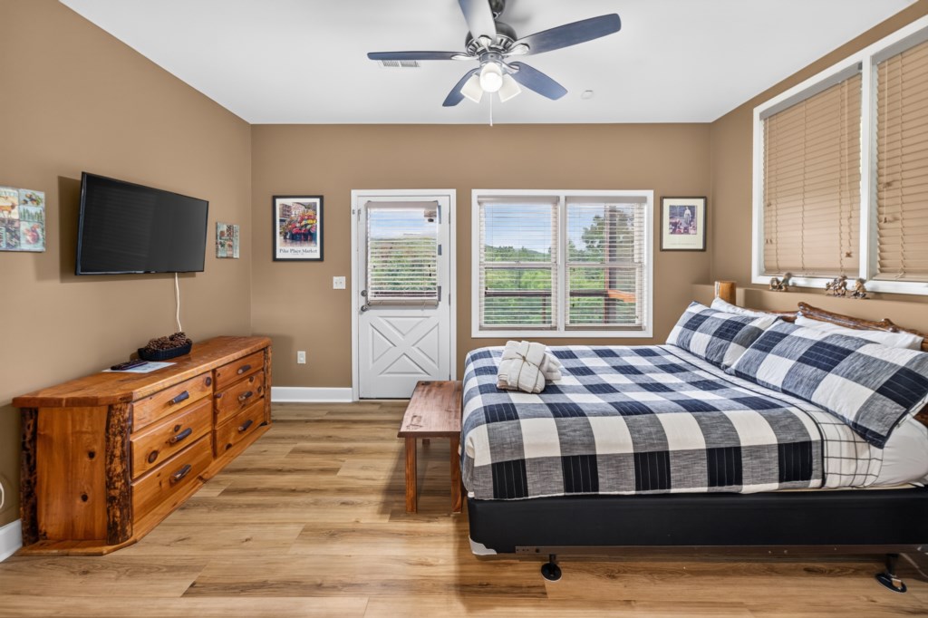 Cozy bedroom with a king bed, flat-screen TV, and scenic view from the window.