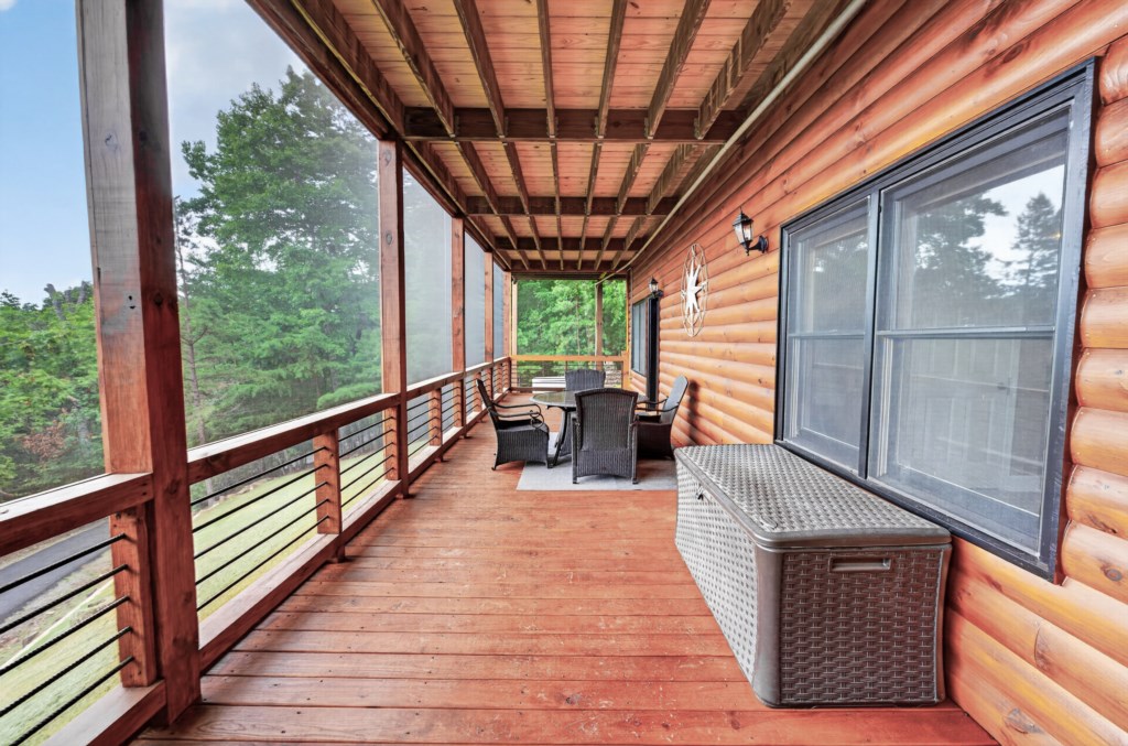 Spacious covered deck with forest views, perfect for relaxing or dining al fresco.
