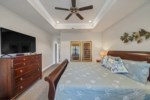 The primary bedroom offers a flat screen television, ceiling fan, and attached bathroom