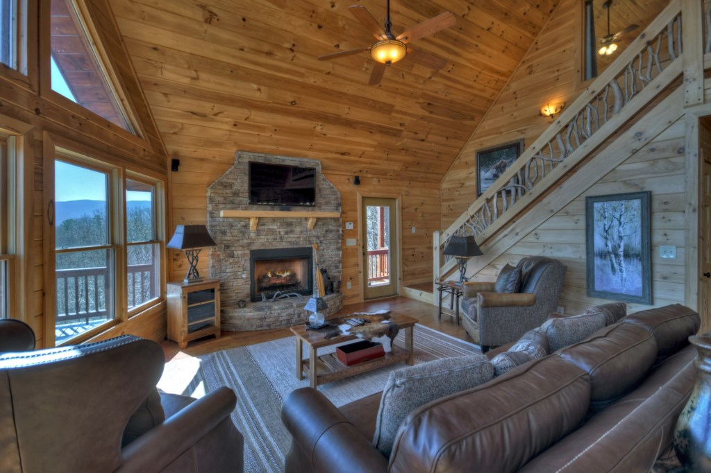 Main level living room with floor to ceiling windows and seasonal gas log fireplace 