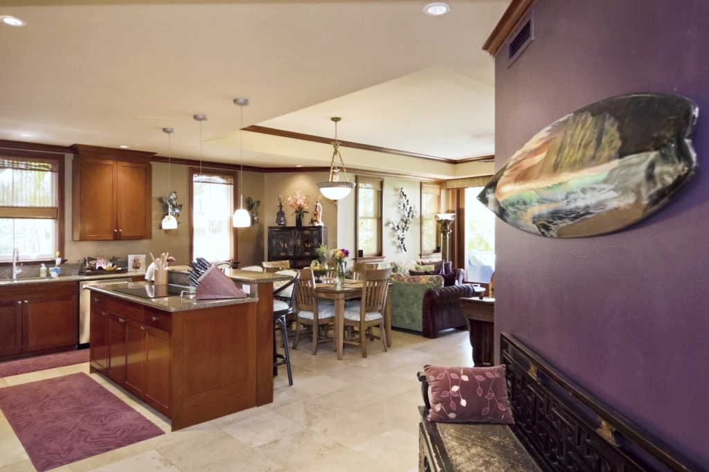 Warm wood cabinetry and tropical accents fill this open kitchen and dining space with island charm.