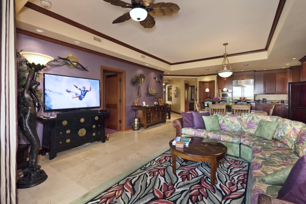Watch your favorite shows in a vibrant living room with tropical touches, cozy couch, and flat screen TV.
