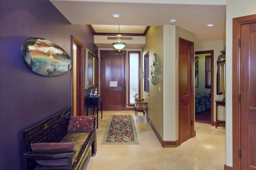 Inviting hallway with island inspired decor and polished wood finishes sets a stylish tone inside.

