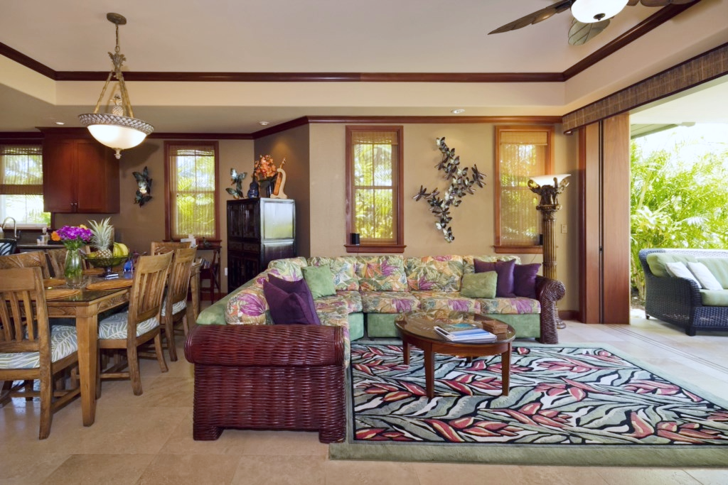 Colorful living room with floral sectional, woven textures, and bright views of the outdoor space.