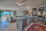 Country chic kitchen has concrete countertops, solid wood cabinetry, open shelving, and all major appliances 