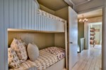 Adjoining the bunk room is the third guest room, queen, with a pocket door for privacy