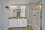Attached bathroom with double vanity, soaking tub, walk-in shower, large closet, and private water closet