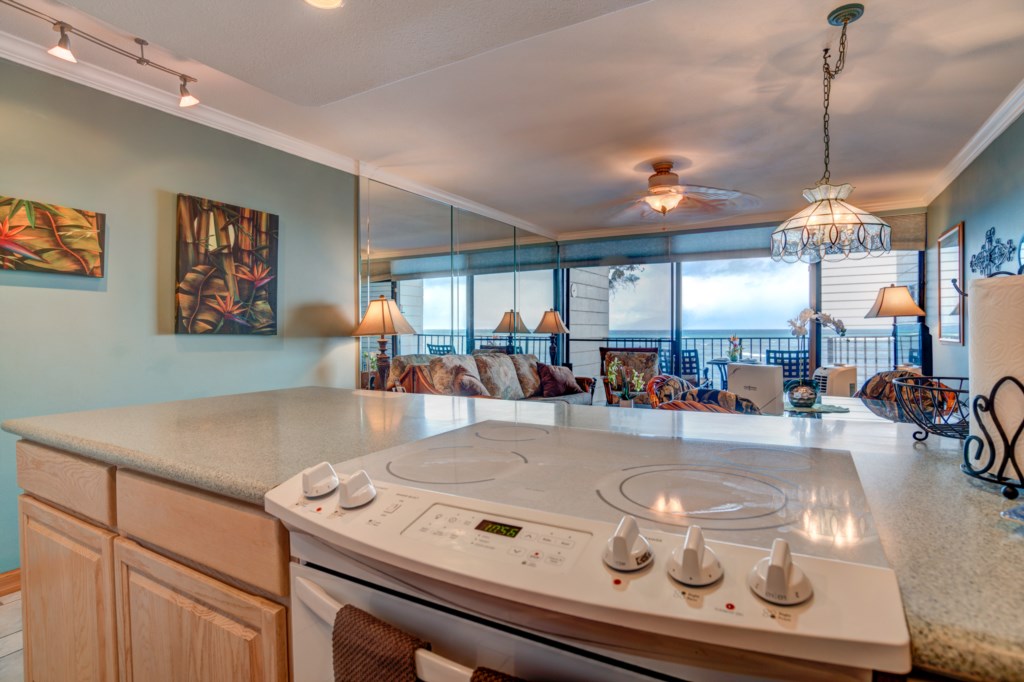 Fully equipped kitchen with custom cabinets, bright lighting, and updated appliances.