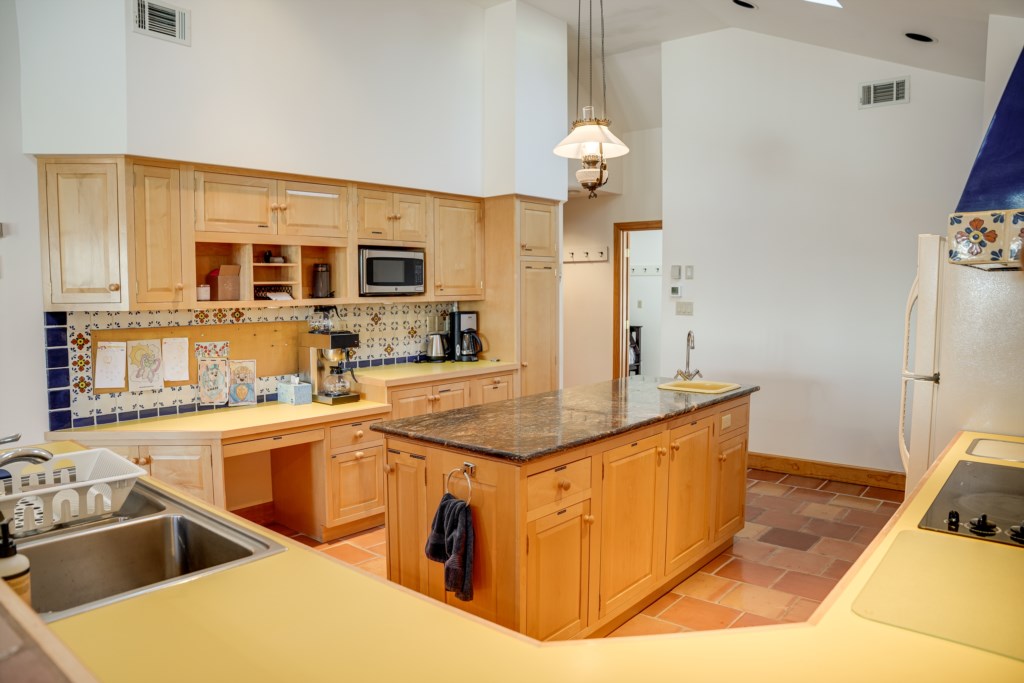 Fun yellow countertops and beautiful tile backsplash in the kitchen area. 