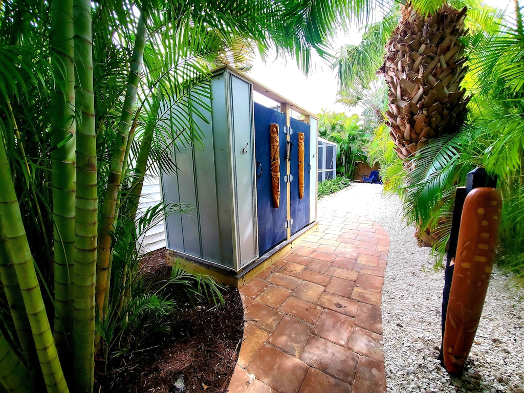 Twin enclosed outdoor showers with hot water and blue sky views.