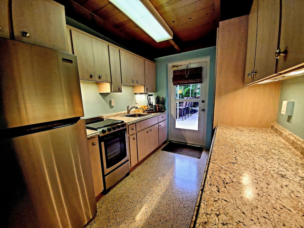 Enjoy the fully stocked kitchen leading out to the tropical back yard.