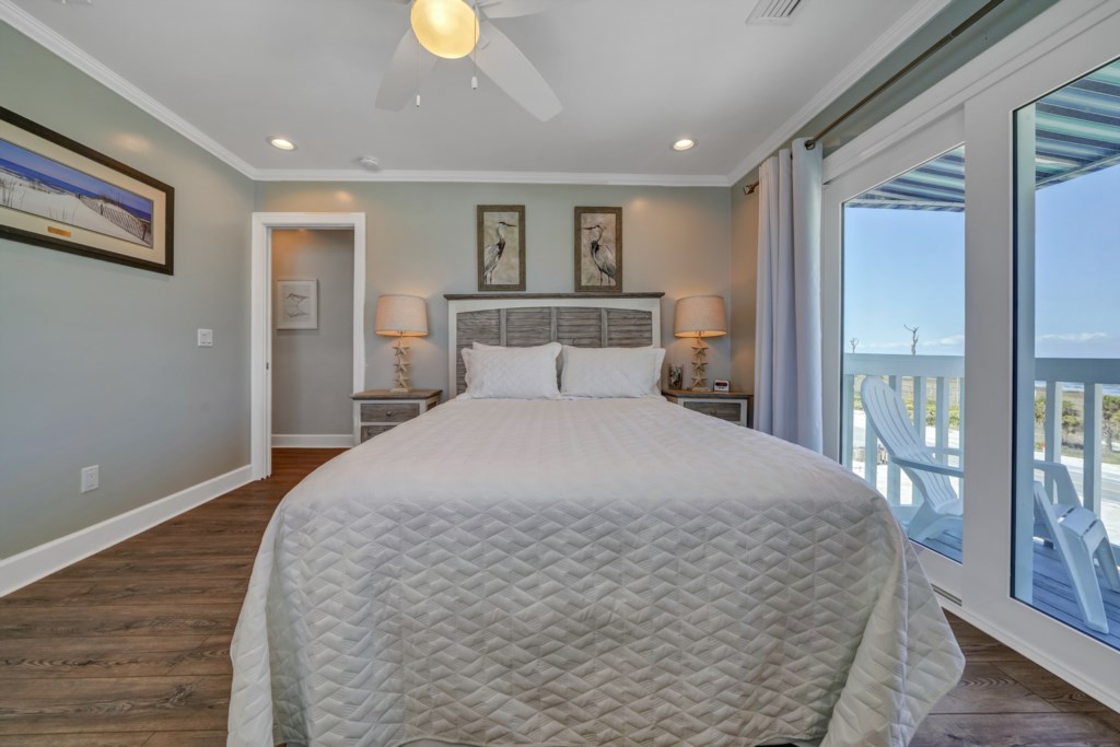 Queen guest bedroom with private balcony, cable television, and ceiling fan