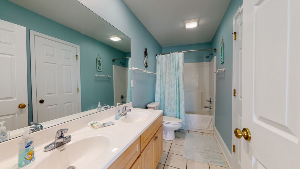 attached bathroom with double vanity and shower/tub combination 