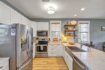 Beautiful stone countertops, large farmhouse sink, and recessed lighting making the kitchen modern and functional 