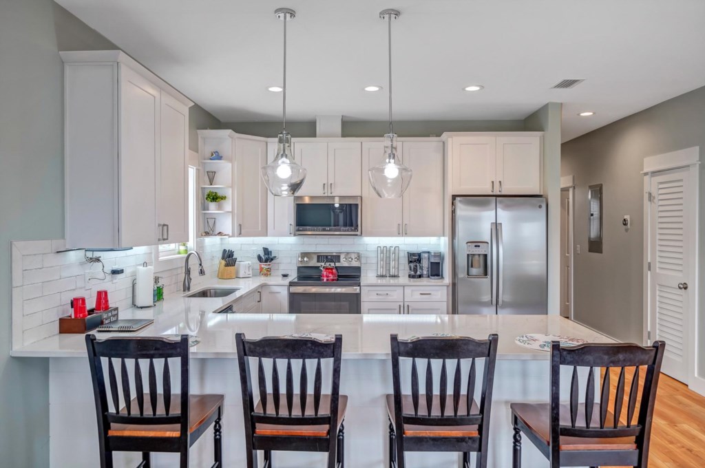 The kitchen is bright and modern and fully stocked with dishes, utensils, and all major appliances 