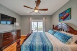 Primary bedroom with king bed, ceiling fan, cable television, balcony access and attached bath