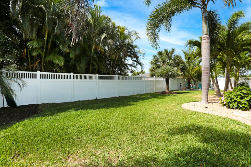 Spacious backyard with lush greenery and privacy fence for relaxation and outdoor activities.