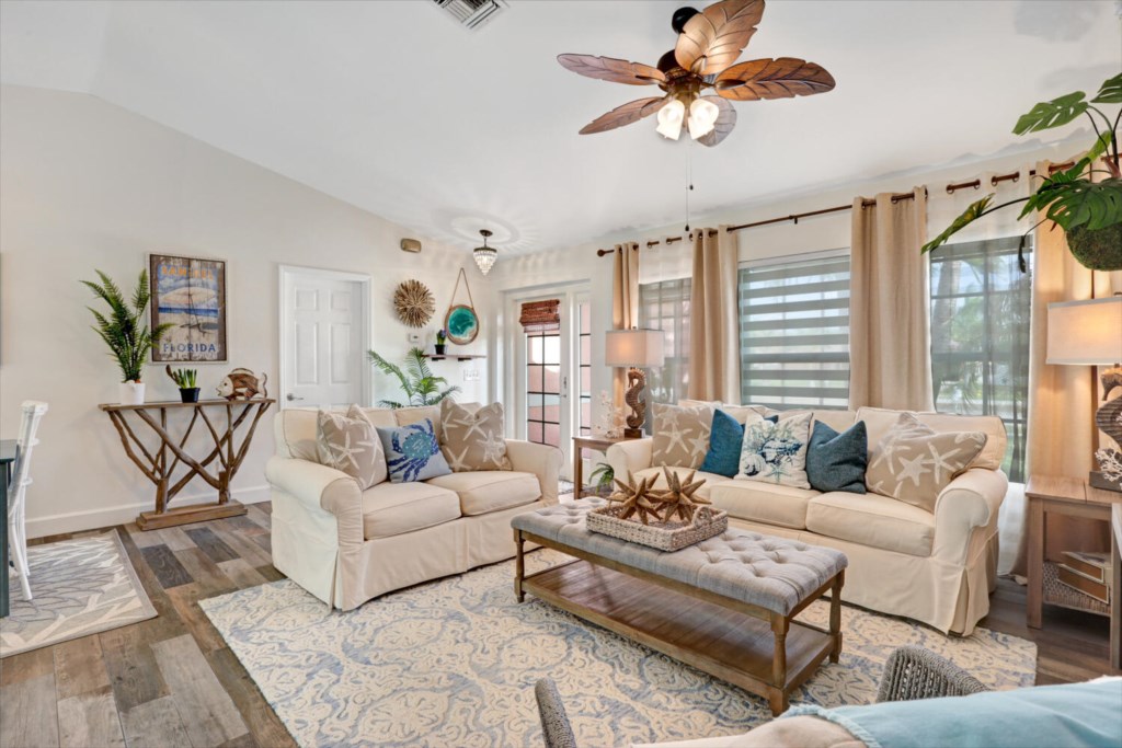 Coastal-themed living room with plush seating and natural light, perfect for relaxation.