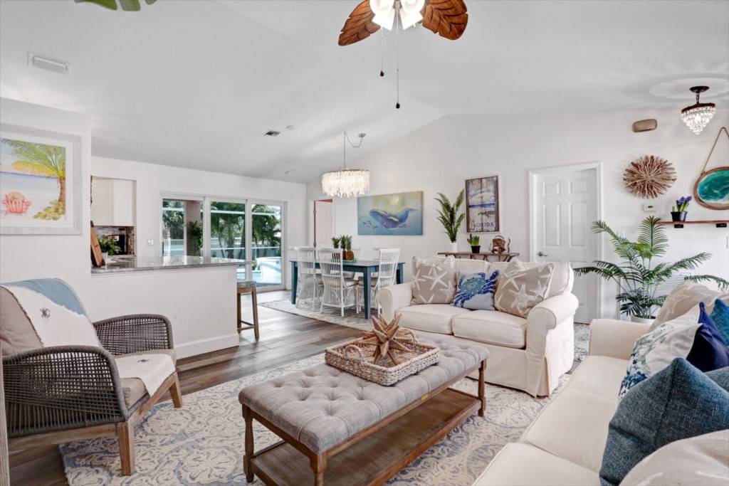Bright and airy living room with coastal decor and pool view.