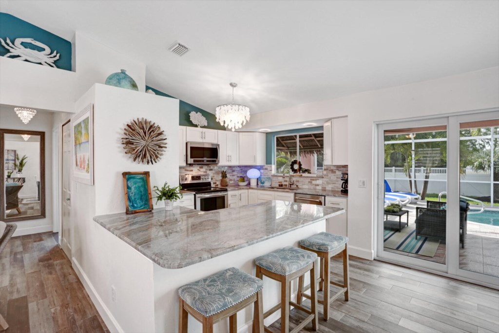 Modern kitchen with granite counters and pool view, perfect for entertaining.